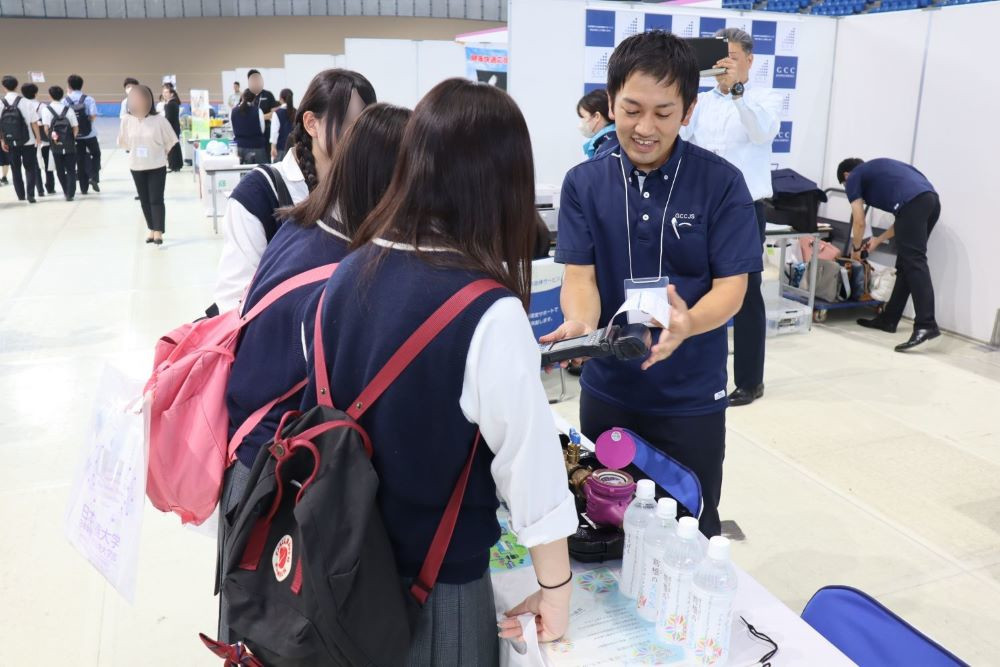 従業員が高校生へ水道検針業務の説明をしている写真